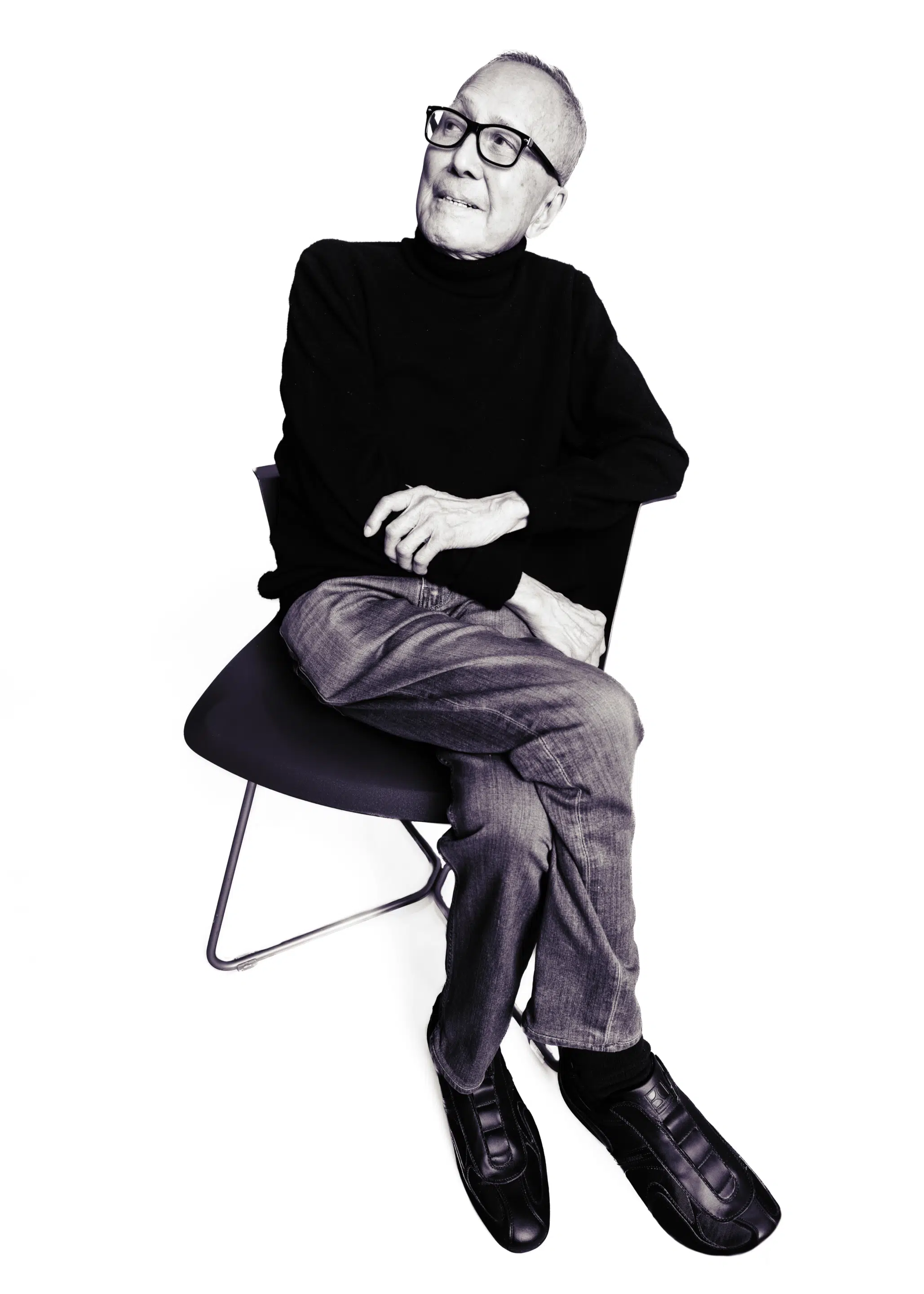 Jimmy Der sitting relaxed on a chair. Black and white photography. 