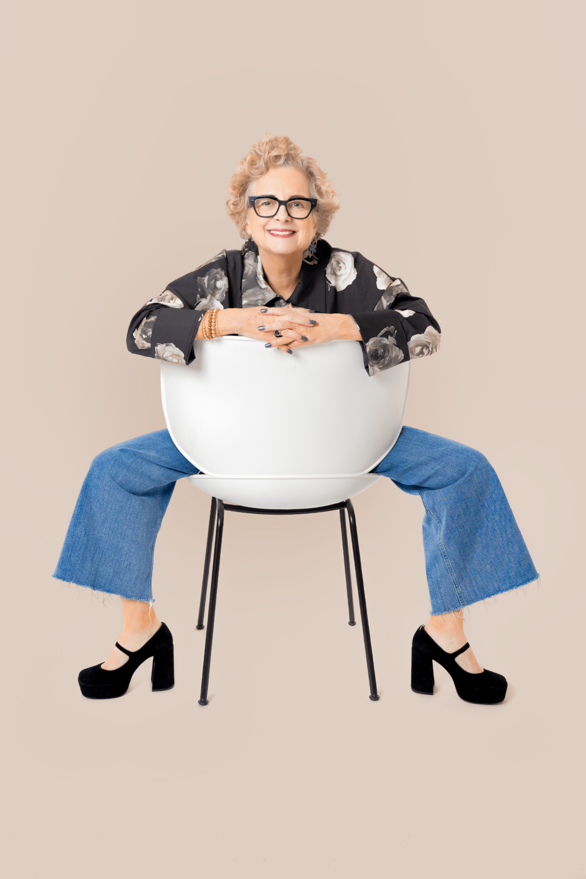 Mag Barry smiles while sitting on a backwards chair.