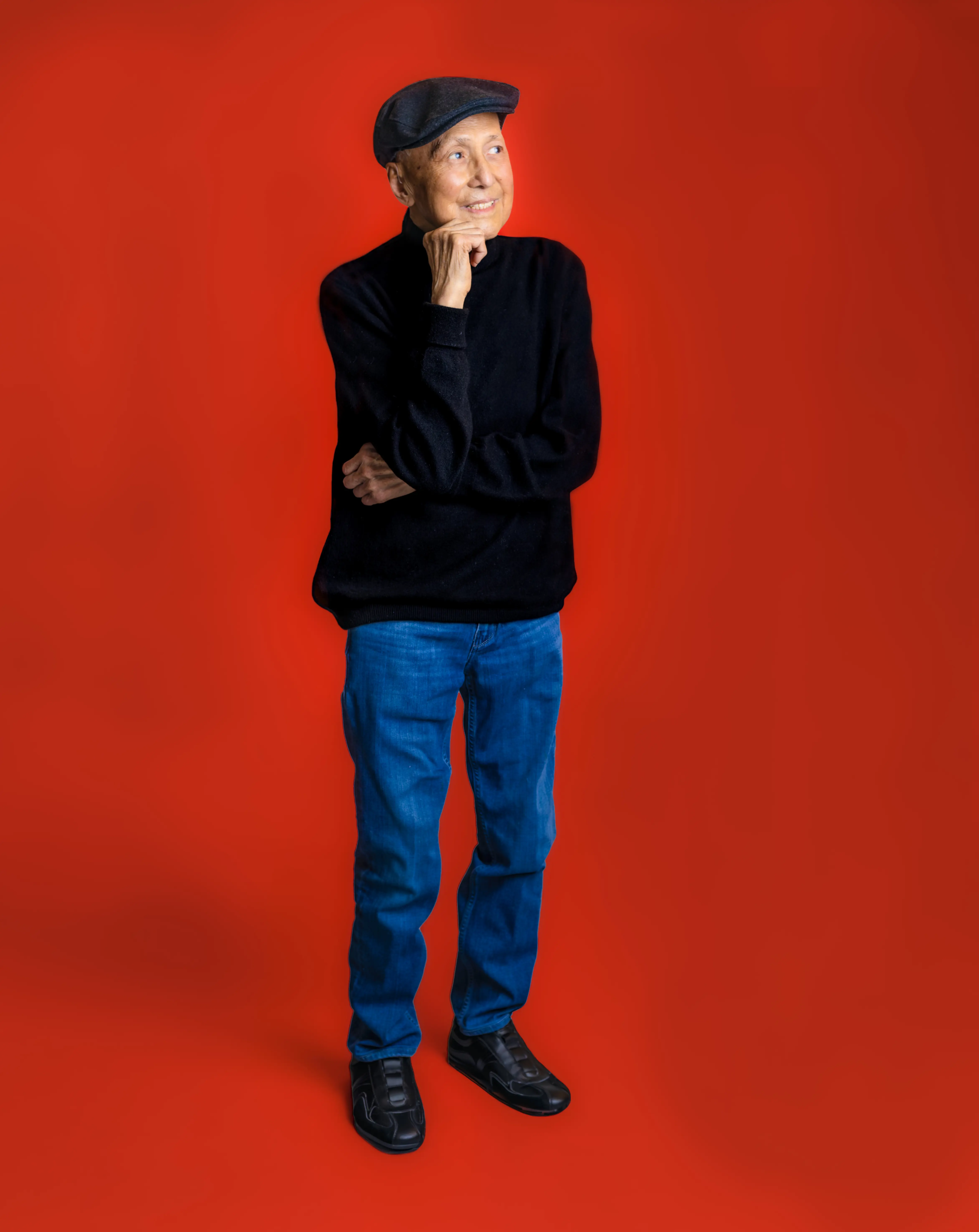 Jimmy standing in front of a bright red backdrop. 